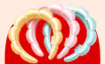 Pastel yellow, pink, and blue bubble headbands arranged on a red background