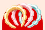 Pastel yellow, pink, and blue bubble headbands arranged on a red background