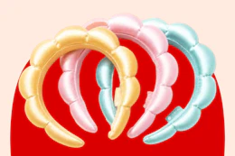 Pastel yellow, pink, and blue bubble headbands arranged on a red background