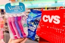 hand holding gillette and venus disposable razors in front of cvs basket