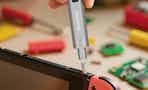 person using mini screwdriver on gaming device