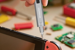 person using mini screwdriver on gaming device