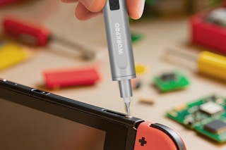 person using mini screwdriver on gaming device