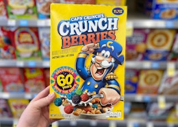 hand holding a box of cap'n captain crunch cereal