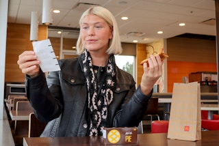 a person looking at a mcdonalds receipt while holding a pumpkin pie