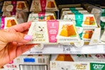 hand holding fancy feast cat food