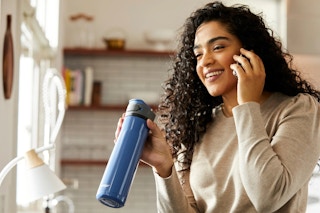 a woman holding a contigo water bottle