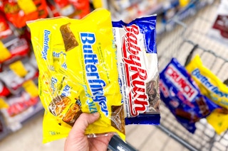 hand holding candy bags with fun size butterfinger and baby ruth