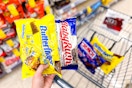 hand holding candy bags with fun size butterfinger and baby ruth