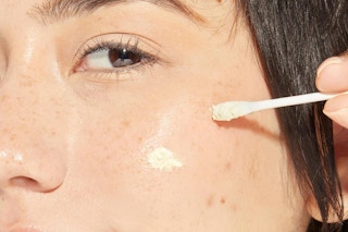 a woman using mario badescu blemish powder on her skin