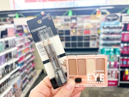 hand holding eyeliners and shadow palette