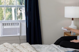 a woman using a window ac unit