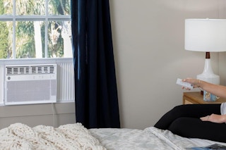a woman using a window ac unit