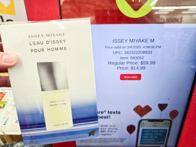 person scanning a fragrance on a cvs price kiosk for $14.99