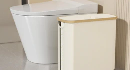 a toilet paper storage basket next to a toilet 