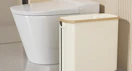 a toilet paper storage basket next to a toilet
