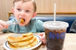 A child eating a stack of pancakes at ihop
