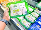 Hand holding Perdue Harvestland Chicken Drumsticks at Walmart