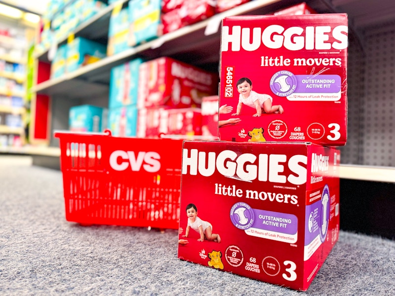 two stacked boxes of huggies diapers next to cvs shopping basket