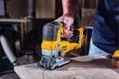  Man using the DEWALT 20V MAX XR Jig Saw on a board.