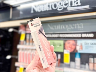 person holding neutrogena mascara in front of a display
