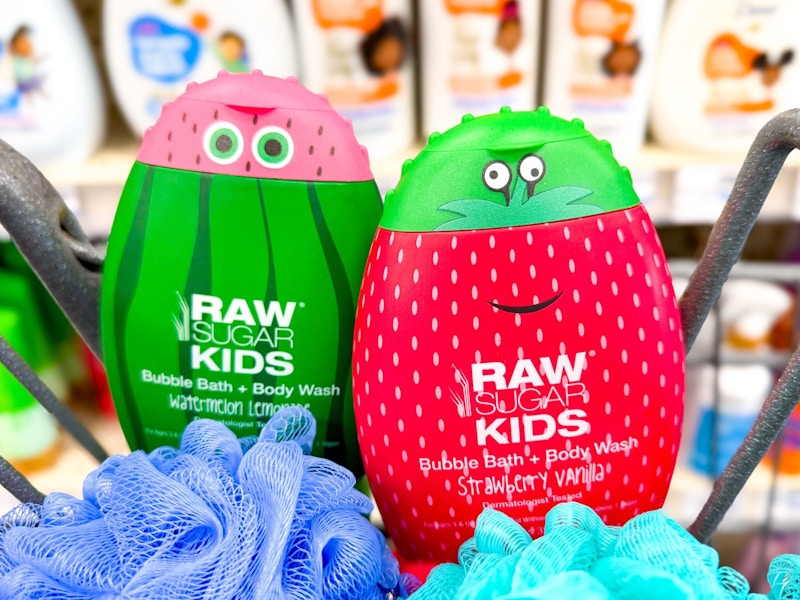 2 bottles of raw sugar kids body wash in a cart with loofahs