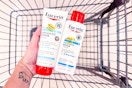 person holding eucerin lotions over a cart