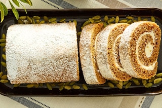 Lifestyle image of Walmart's brand "Freshness Guaranteed" pumpkin cake roll in a dish with pumpkin seeds