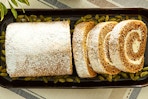 Lifestyle image of Walmart's brand "Freshness Guaranteed" pumpkin cake roll in a dish with pumpkin seeds
