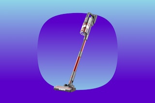 A stick vacuum with a red handle