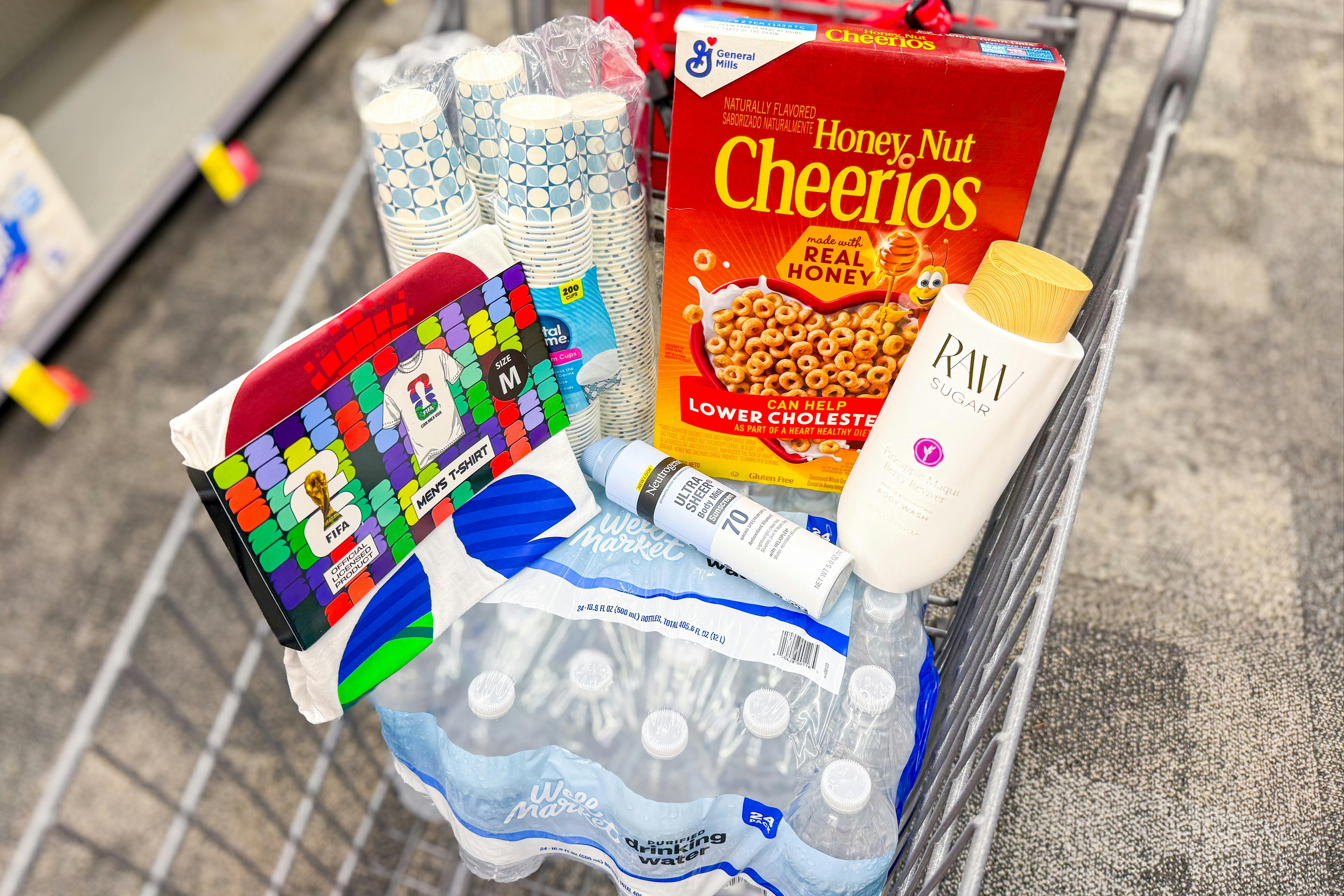 Shopping cart with Cheerios, Neutrogena, Raw Sugar, cups, water, and a FIFA t-shirt