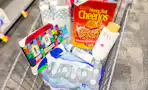 Shopping cart with Cheerios, Neutrogena, Raw Sugar, cups, water, and a FIFA t-shirt