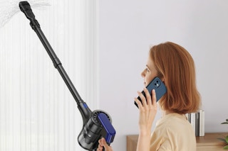 a woman using a cordless vacuum