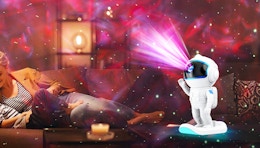 an galaxy star projector showing pink and red lights on a ceiling