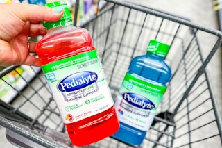 hand holding pedialyte bottle with a second bottle in the cart