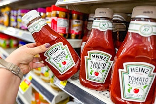 hand holding a bottle of heinz ketchup
