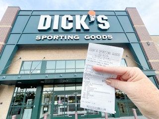 holding a receipt in front of dicks sporting goods