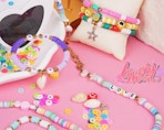 colorful bracelets and beads on a pink background