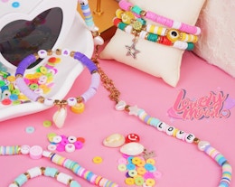 colorful bracelets and beads on a pink background