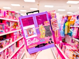 hand holding a barbie ultimate closet in a target aisle