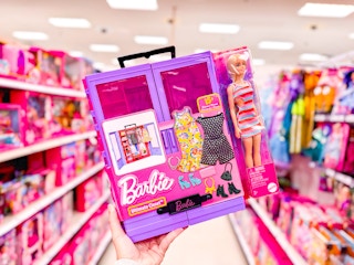 hand holding a barbie ultimate closet in a target aisle