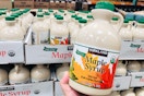 Kirkland Maple Syrup held in front of pallet of maple syrup