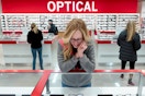 a woman looking at glasses in a glass case at the Costco Optical center