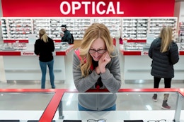 a woman looking at glasses in a glass case at the Costco Optical center