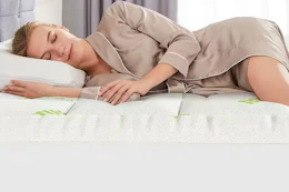 a woman sleeping on a mattress topper