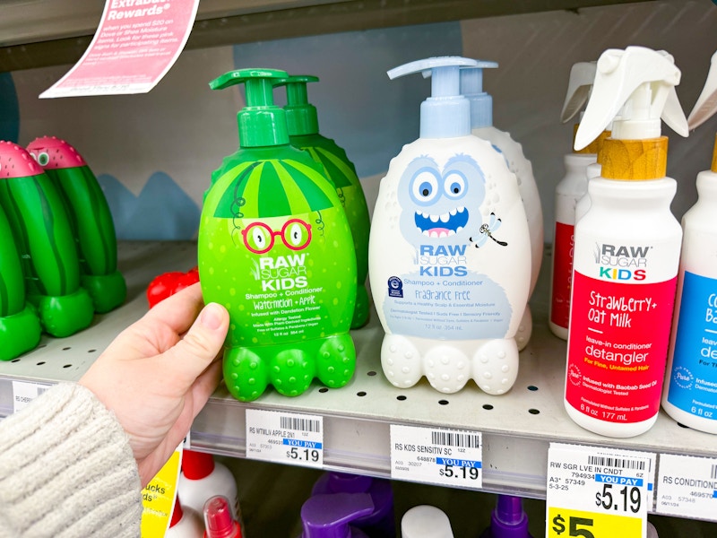 person grabbing a bottle of raw sugar kids shampoo off the shelf