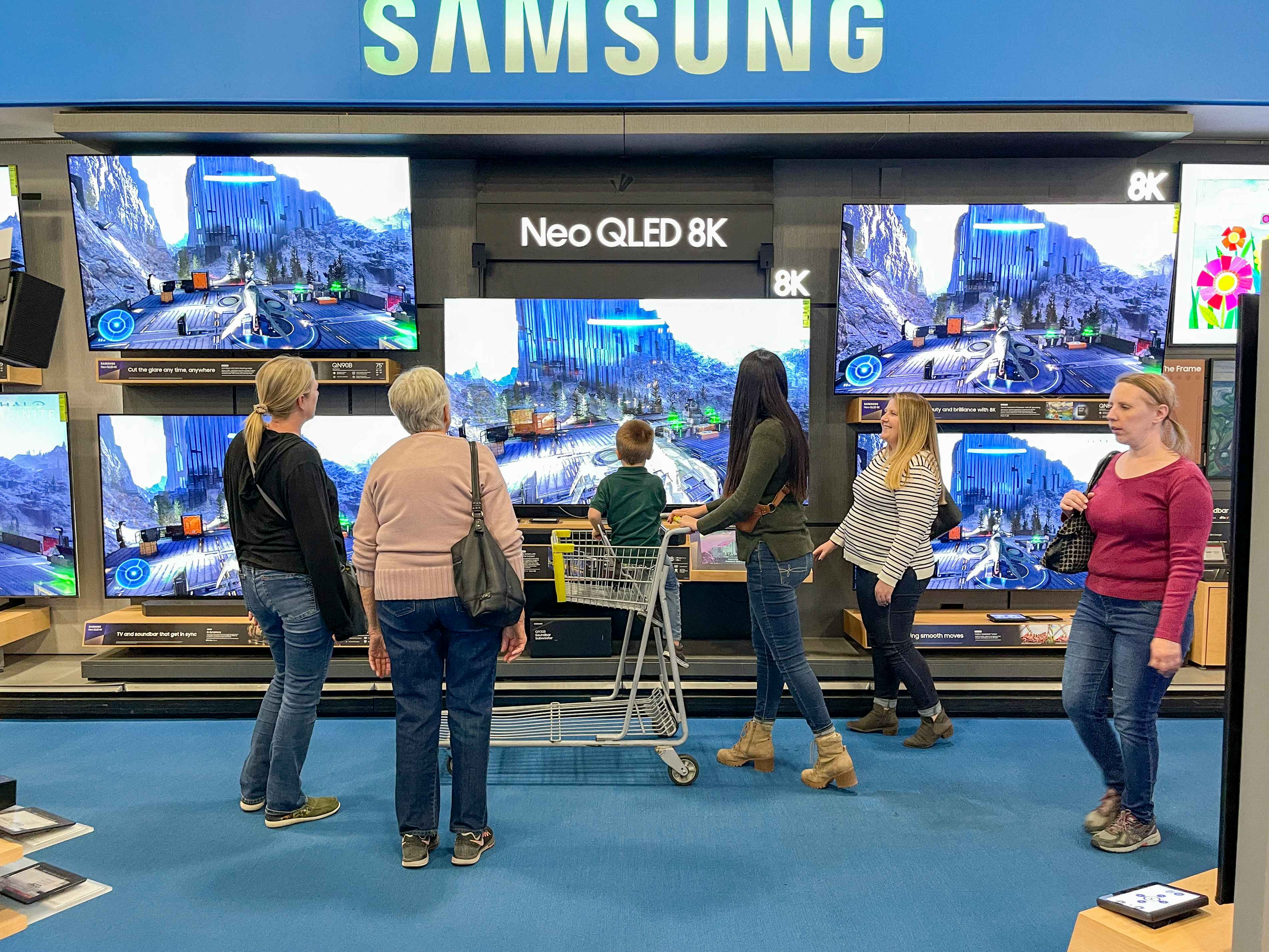 People looking at Samsung TVs at Best Buy.