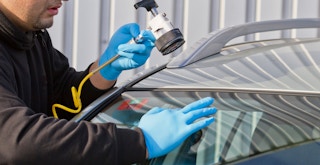 a person repairing a crack in windshield