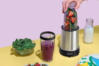 a person using a blender to make a smoothie