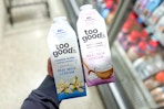 hand holding 2 bottles of too good & co coffee creamer at target